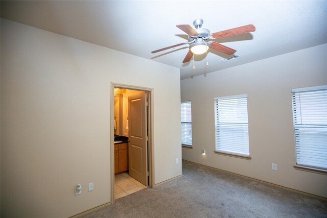unfurnished bedroom featuring ceiling fan, visible vents, and light colored carpet