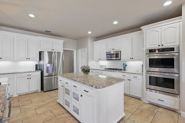 820 Clearlake Dr, Prosper, TX 75078 - kitchen with appliances with stainless steel finishes, backsplash, white cabinets, a center island, and recessed lighting