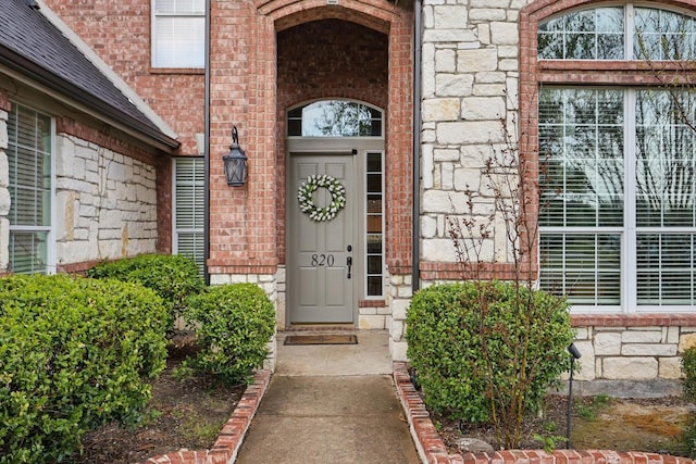 820 Clearlake Dr, Prosper, TX 75078 - view of exterior entry with stone siding, brick siding, and a shingled roof