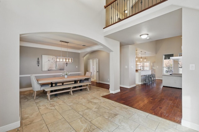 820 Clearlake Dr, Prosper, TX 75078 - dining area with arched walkways, crown molding, baseboards, and a chandelier