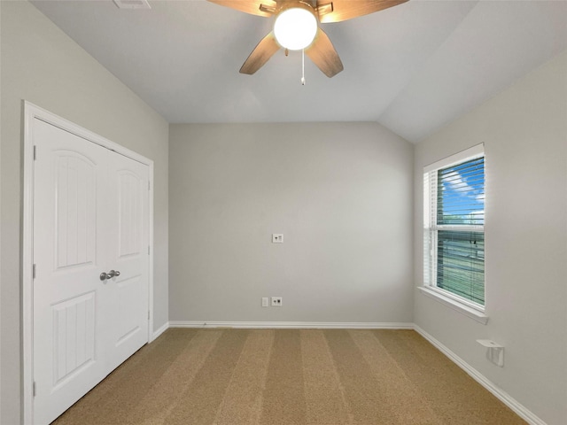unfurnished bedroom with baseboards, lofted ceiling, ceiling fan, and carpet