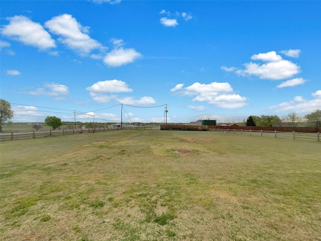 view of yard with fence and a rural view