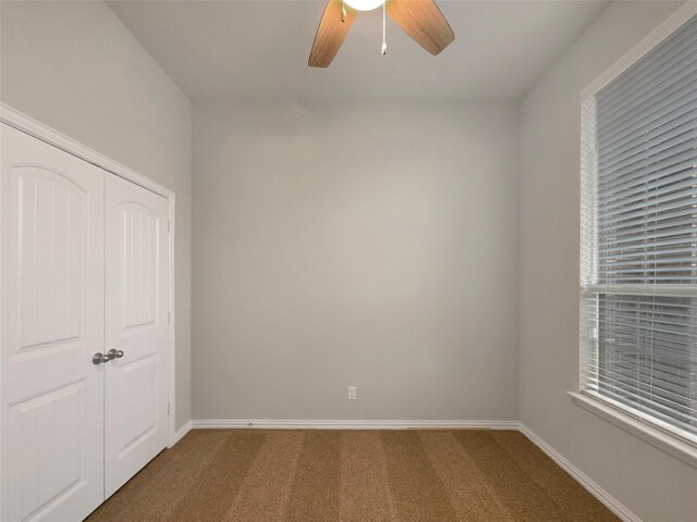 unfurnished bedroom with carpet floors, baseboards, and a closet