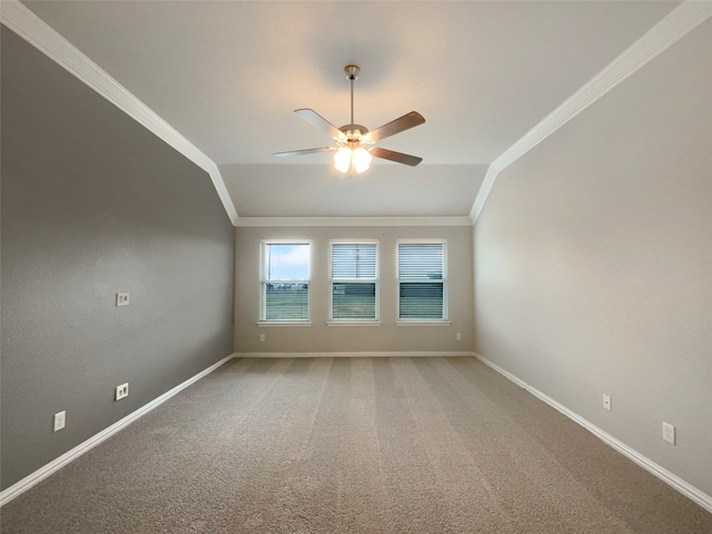 carpeted empty room featuring baseboards, vaulted ceiling, ceiling fan, and ornamental molding