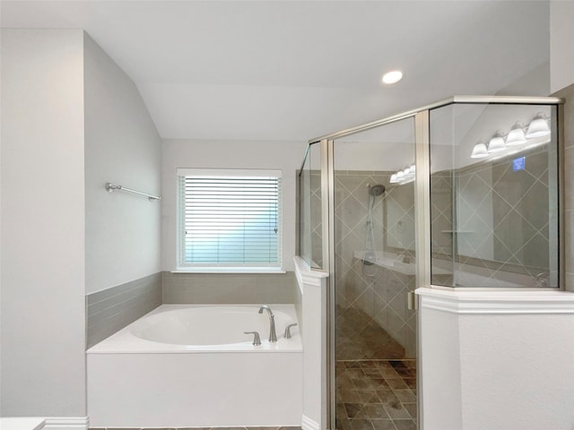 bathroom with a stall shower, lofted ceiling, a garden tub, and recessed lighting