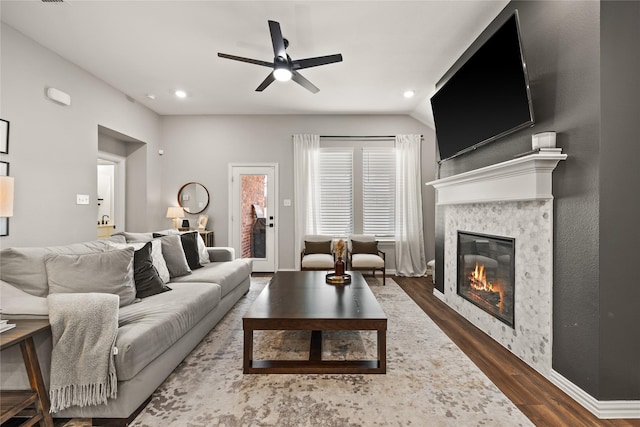 living area featuring a glass covered fireplace, recessed lighting, ceiling fan, and dark wood-style flooring