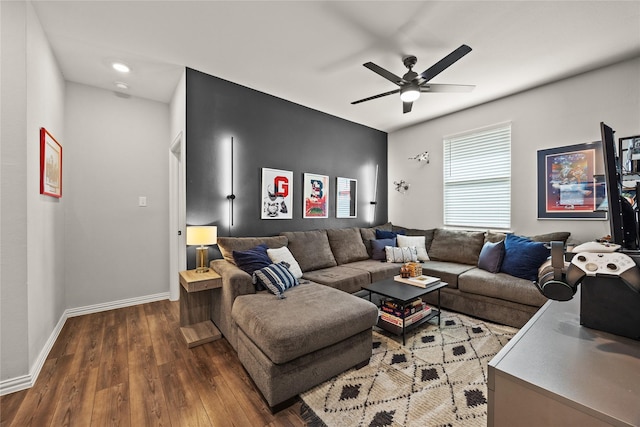 living room featuring ceiling fan, baseboards, and wood finished floors