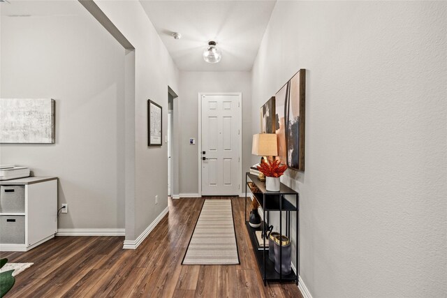 interior space featuring baseboards and dark wood-style floors