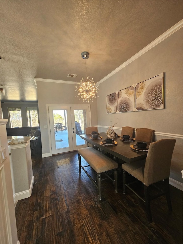 dining room with french doors, a textured ceiling, dark wood-type flooring, and ornamental molding