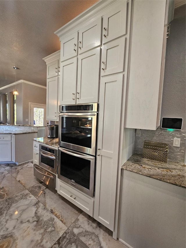 kitchen featuring a textured ceiling, a warming drawer, backsplash, stainless steel double oven, and crown molding