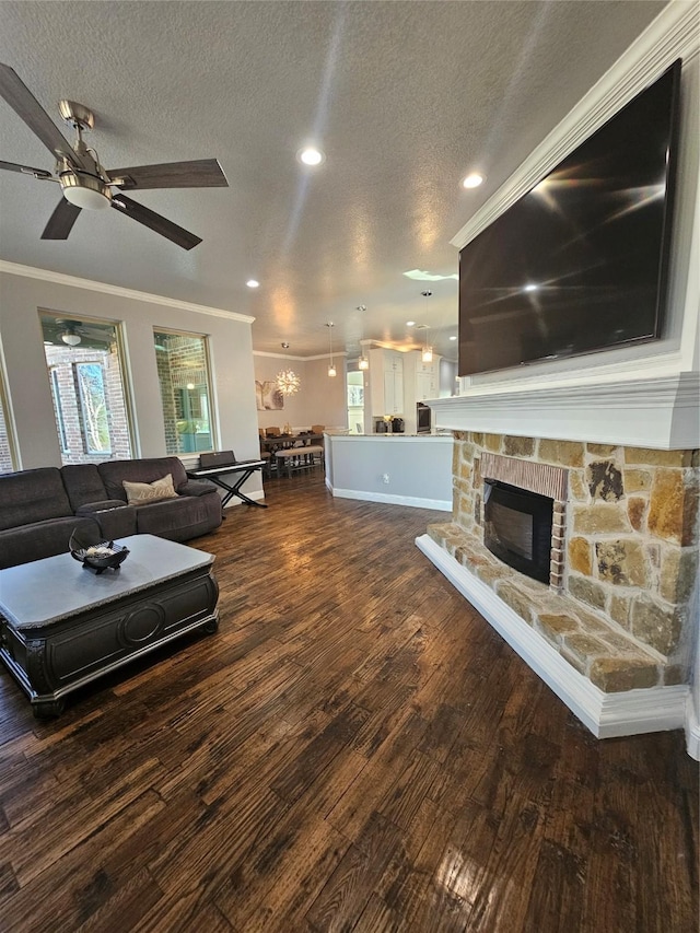 living room with wood finished floors, a healthy amount of sunlight, a textured ceiling, and crown molding