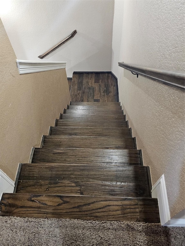 staircase featuring a textured wall