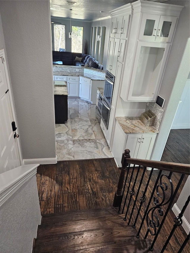 staircase featuring marble finish floor and baseboards