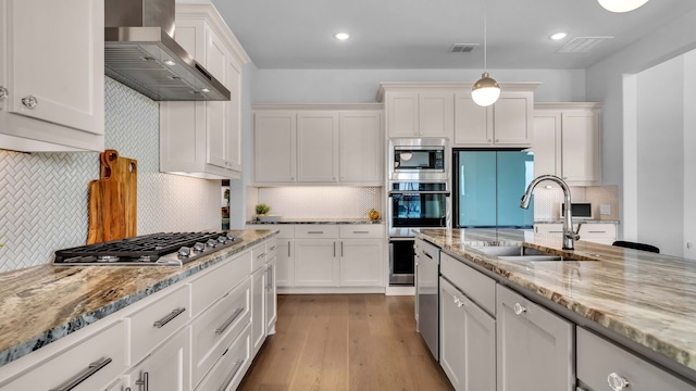 1651 Wynne Ave, Prosper, TX 75078 - kitchen with appliances with stainless steel finishes, a sink, wall chimney range hood, tasteful backsplash, and recessed lighting