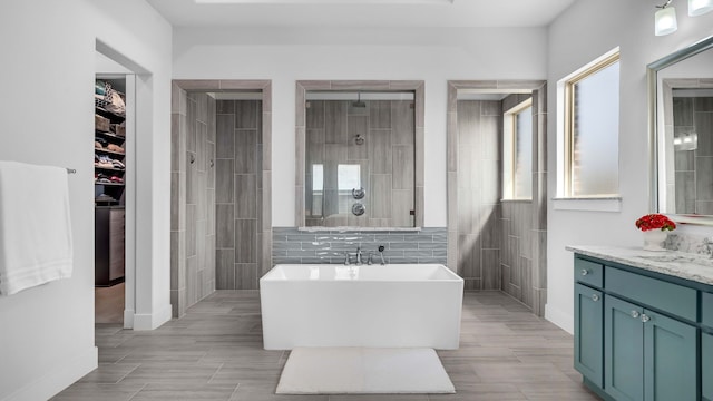 1651 Wynne Ave, Prosper, TX 75078 - bathroom with a walk in shower, tile walls, a soaking tub, vanity, and wood tiled floors