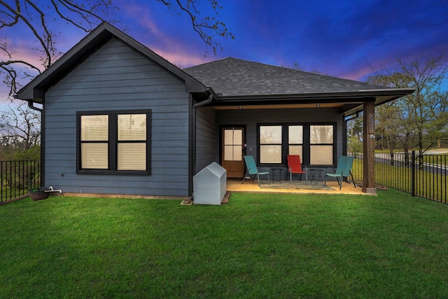 631 E Texas St, Denison, TX 75021 - back of property with a yard, a shingled roof, a fenced backyard, and a patio area
