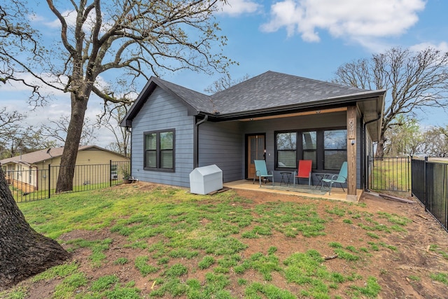 631 E Texas St, Denison, TX 75021 - back of property with a patio, a lawn, a fenced backyard, and roof with shingles