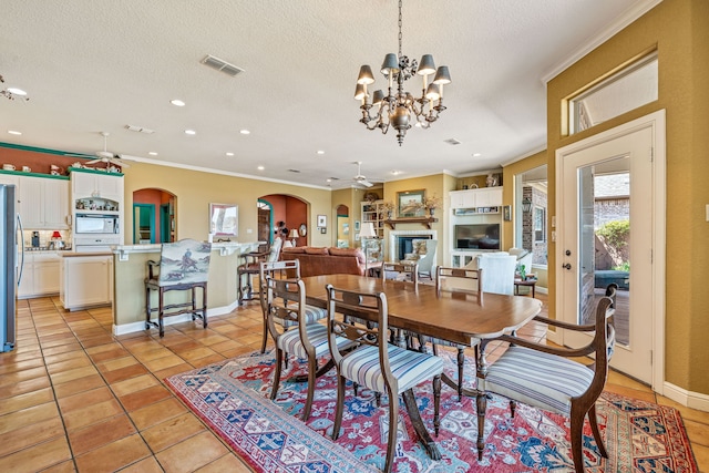 4204 Bluff View Dr, Granbury, TX 76048 - dining room featuring light tile patterned floors, arched walkways, visible vents, and ceiling fan with notable chandelier