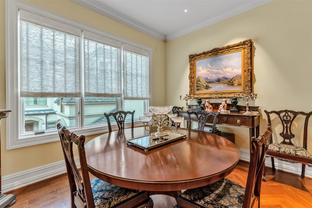 dining room featuring baseboards, wood finished floors, and ornamental molding