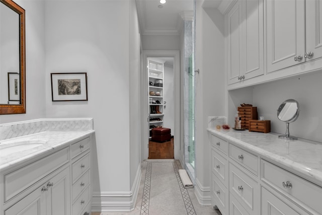 full bath featuring a shower, baseboards, ornamental molding, vanity, and tile patterned flooring