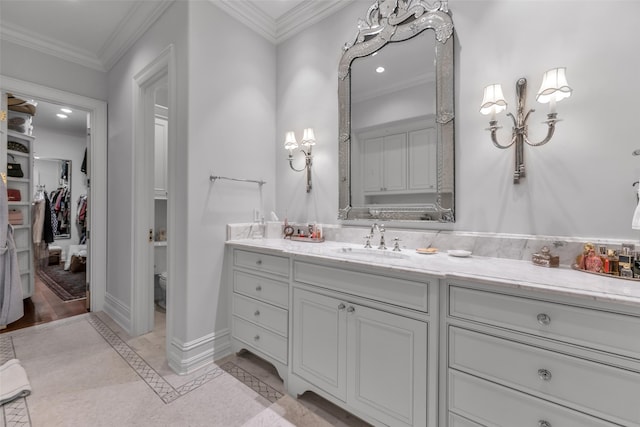 bathroom with baseboards, crown molding, toilet, and vanity