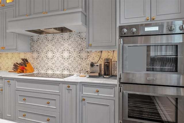 kitchen featuring premium range hood, light countertops, stainless steel double oven, and black electric stovetop