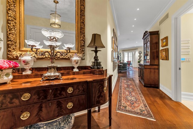 corridor with recessed lighting, dark wood-style flooring, ornamental molding, baseboards, and visible vents