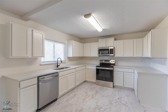 1318 Burger St, Abilene, TX 79603 - kitchen featuring stainless steel appliances, a sink, light marble finish flooring, white cabinets, and light countertops