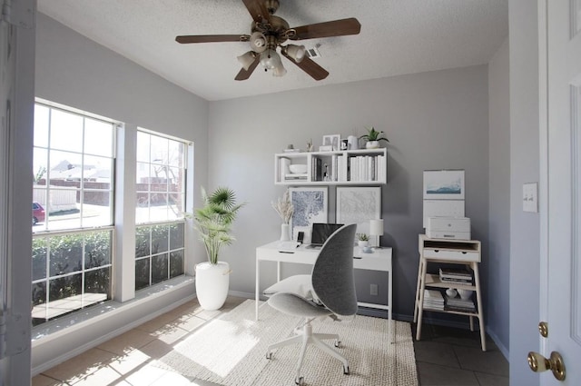 tiled office with ceiling fan and baseboards