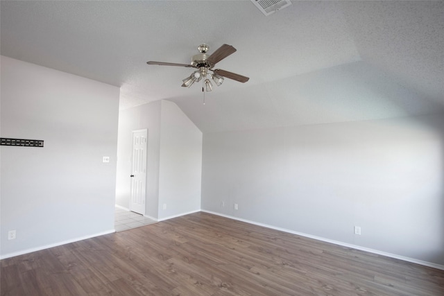 bonus room featuring a ceiling fan, visible vents, vaulted ceiling, baseboards, and wood finished floors