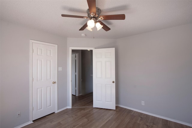 unfurnished bedroom featuring baseboards, wood finished floors, ceiling fan, and a textured ceiling