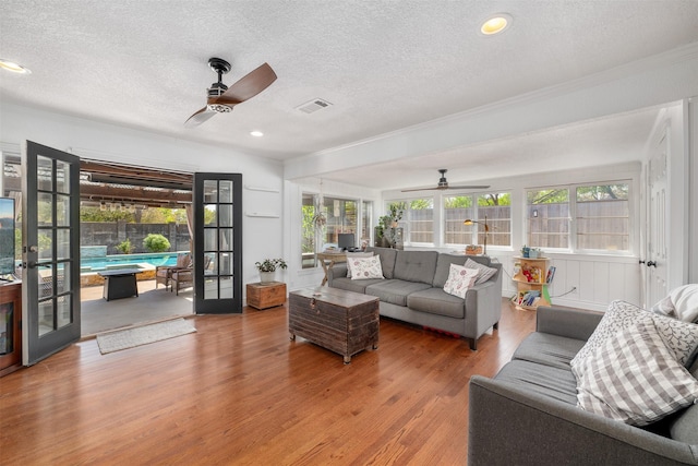 320 Eastwood Ave, Fort Worth, TX 76107 - living area with ceiling fan, a textured ceiling, healthy amount of natural light, wood finished floors, and crown molding