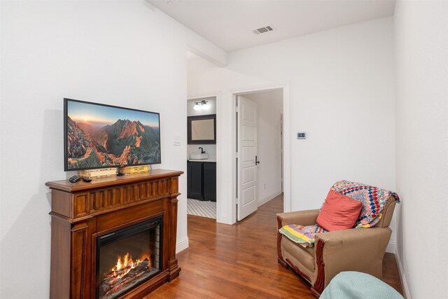 320 Eastwood Ave, Fort Worth, TX 76107 - sitting room with wood finished floors, a warm lit fireplace, and baseboards
