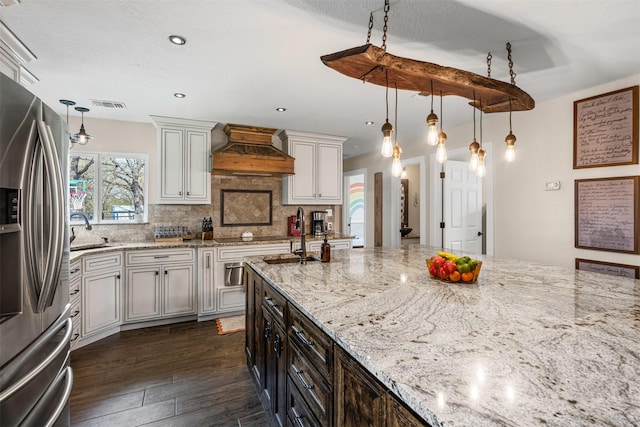 161 Mariah Dr, Weatherford, TX 76087 - kitchen with custom exhaust hood, stainless steel refrigerator with ice dispenser, dark wood finished floors, a sink, and backsplash