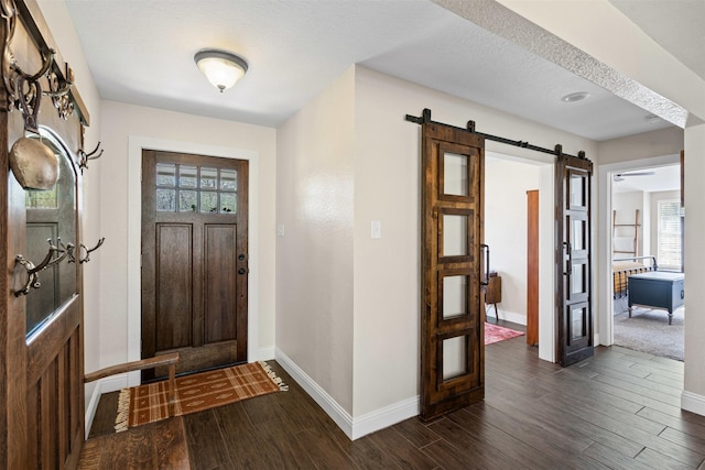 161 Mariah Dr, Weatherford, TX 76087 - foyer featuring a barn door, baseboards, and dark wood-type flooring