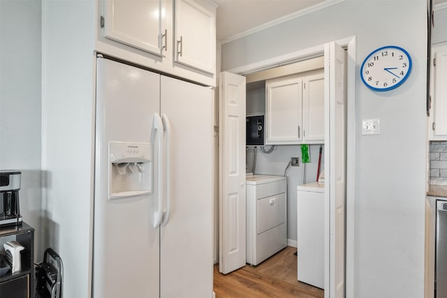 kitchen with ornamental molding, independent washer and dryer, light wood-style floors, white fridge with ice dispenser, and white cabinetry