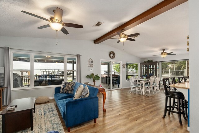 living room featuring wood finished floors, visible vents, and a ceiling fan
