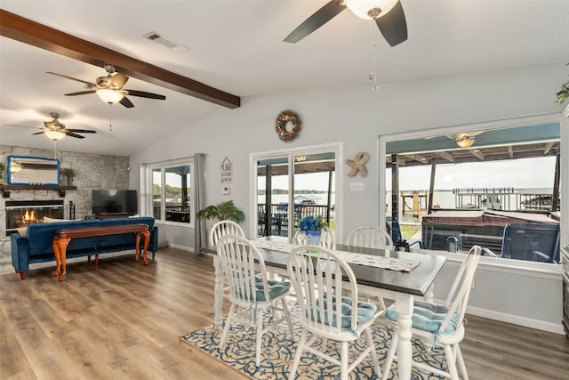 dining area featuring wood finished floors, visible vents, a ceiling fan, and vaulted ceiling with beams