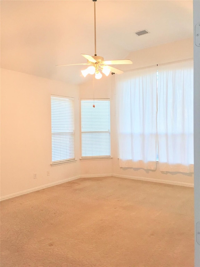 carpeted empty room with a ceiling fan, baseboards, and visible vents