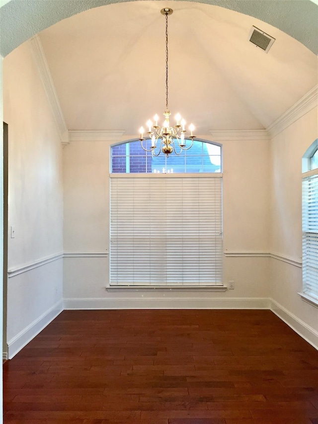 unfurnished dining area with ornamental molding, visible vents, a chandelier, and wood finished floors