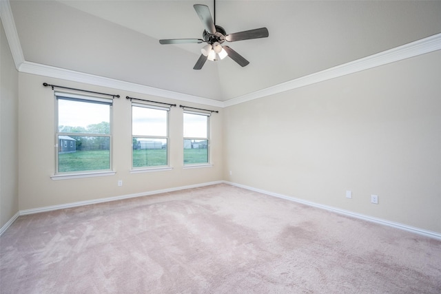 carpeted spare room featuring a ceiling fan, crown molding, baseboards, and lofted ceiling