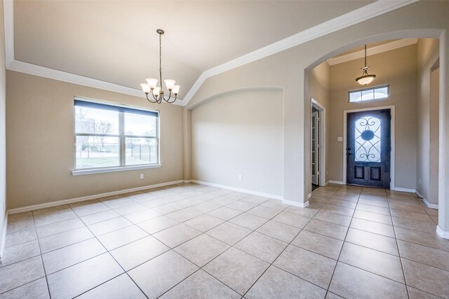foyer with lofted ceiling, an inviting chandelier, light tile patterned floors, ornamental molding, and arched walkways