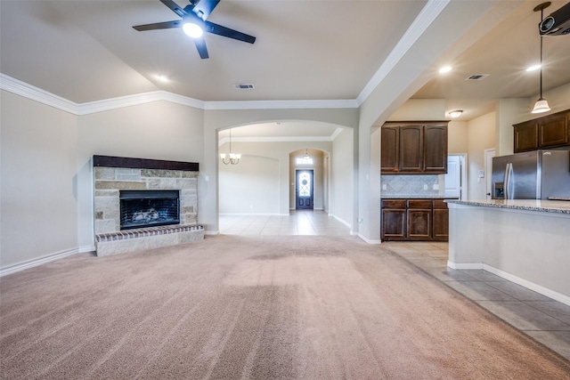 unfurnished living room featuring visible vents, crown molding, ceiling fan, light carpet, and light tile patterned floors