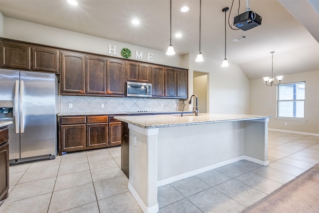 kitchen with light tile patterned floors, stainless steel appliances, a sink, visible vents, and light stone countertops