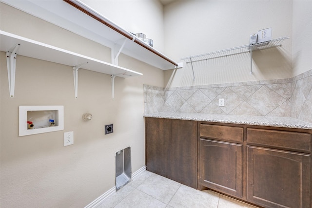 clothes washing area with light tile patterned flooring, hookup for an electric dryer, cabinet space, and hookup for a washing machine
