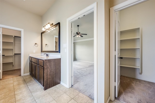 bathroom featuring vanity, tile patterned floors, a spacious closet, and a ceiling fan