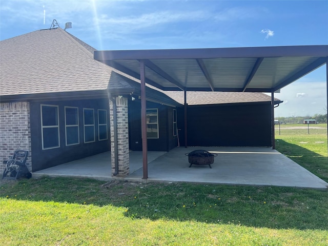 view of patio / terrace featuring an attached carport and an outdoor fire pit