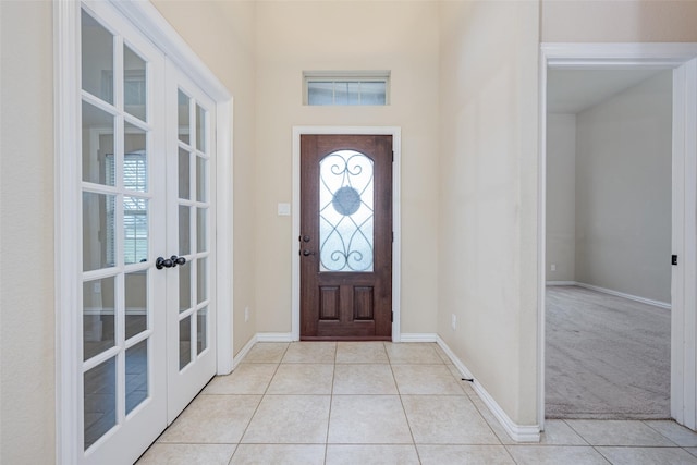 entrance foyer featuring plenty of natural light, baseboards, french doors, and light tile patterned floors