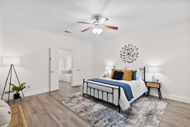 bedroom with visible vents, baseboards, and wood finished floors