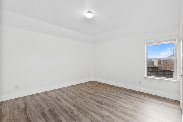 empty room with baseboards and wood finished floors